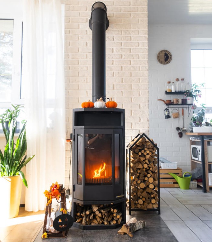 Poêle à bois en fonctionnement – Ramonage C9 Services Poêle à bois moderne en fonte allumé dans un salon lumineux à Arcachon, prêt pour un ramonage professionnel.